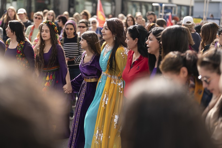 Des femmes dansent, brandissent des pancartes et scandent des slogans lors d'une manifestation marquant la Journée internationale des femmes à Zurich, en Suisse, le samedi 7 mars 2026.