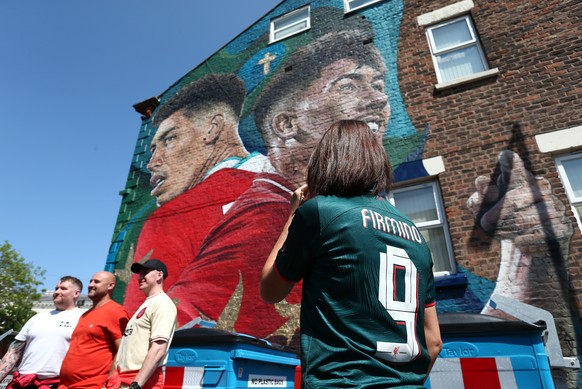epa10640431 Fans pose in front of a mural of Liverpool?s Roberto Firmino near to Anfield Stadium prior to the English Premier League match between Liverpool FC and Aston Villa in Liverpool, Britain, 2 ...