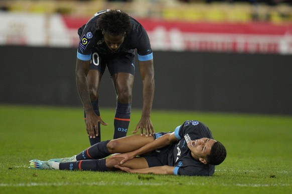 Marseille&#039;s Amine Harit lies on the pitch in pain during the French League One soccer match between Monaco and Marseille at the Stade Louis II in Monaco, Sunday, Nov. 13, 2022. (AP Photo/Daniel C ...