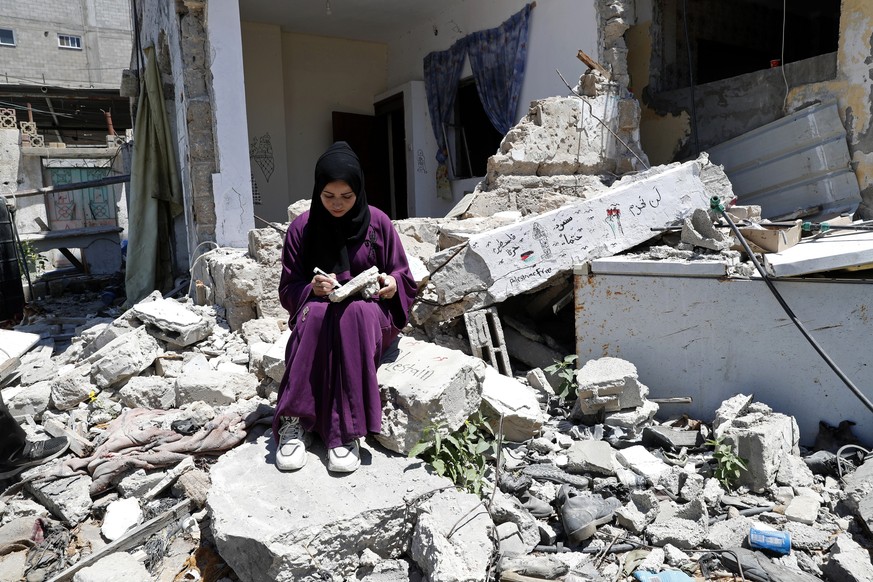 Artist Saja Moussa draws on broken tiles from her family&#039;s house in Rafah refugee camp, southern Gaza Strip, Tuesday, June 15, 2021. The house was damaged last month during an 11-day war between  ...