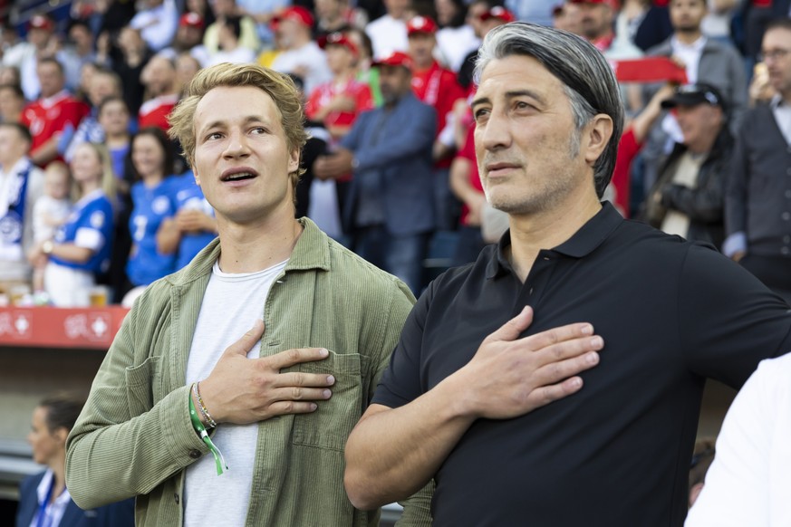 epa11389762 Head coach Murat Yakin (R) of Switzerland and Swiss Ski racer Marco Odermatt sing the national antheme ahead of the international friendly soccer match between Switzerland and Estonia, in  ...