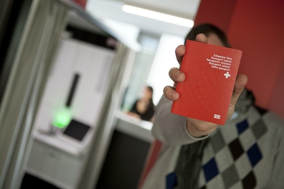 Un homme tient son nouveau passeport Suisse biometrique au nouveau centre de biometrie au Flon, ce vendredi 21 janvier 2011 a Lausanne. Ce centre va recolter les donnees biometriques pour les passepor ...