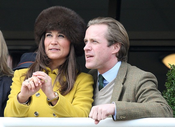 CHELTENHAM, ENGLAND - MARCH 14: Pippa Middleton and friend Tom Kingston watch the Queens Mother Champion Steeple Chase on day 3 of the Cheltenham Festival at Cheltenham Racecourse on March 14, 2013 in ...