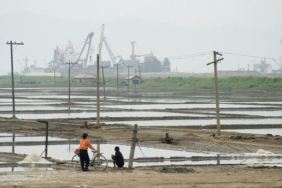 Labourers work in the salt flats near the sea barrage at Nampo in the southwest of North Korea Sunday 06 June 2004. The barrage was built in the 1980s with over one million tons of concrete and tens o ...