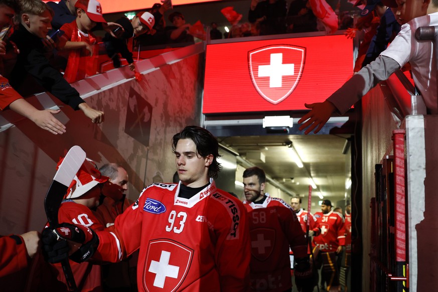 Swiss fans cheer as Theo Rochette, front, Simon Le Coultre, back, and their teammates walk out of the locker room, prior to a friendly ice hockey match between Switzerland and Hungary, Thursday, April ...