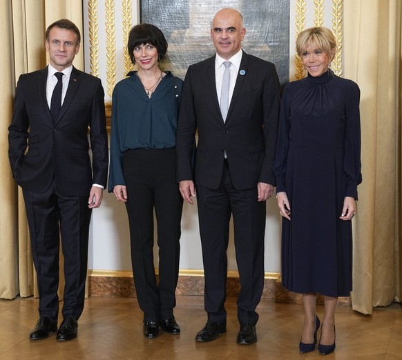 epa10967450 French President Emmanuel Macron (L), and his wife Brigitte Macron (R), greet Switzerland President Alain Berset (C-R) and his wife Muriel Zeender Berset (C-L) as they attend a dinner ahea ...