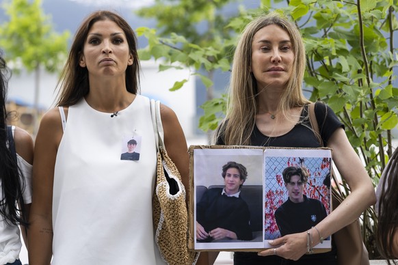 Family of victims, Laetitia Brodard Sitre, left, and Vinciane Stucky, right, with photographs of the victims, before the Crans-Montana primary assembly, following the deadly fire at the "Le Const ...