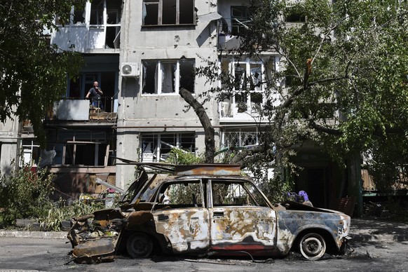 A destroyed car lies next to an apartment building damaged by an overnight missile strike in Sloviansk, Ukraine, Tuesday, May 31, 2022. (AP Photo/Andriy Andriyenko)