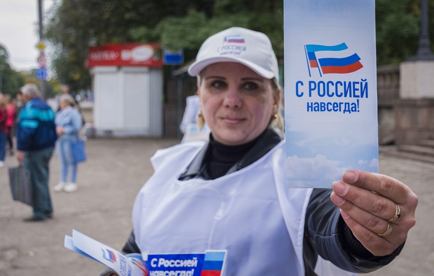 epa10199031 A volunteer distributes campaign booklets reading &#039;With Russia forever&#039; during a campaign rally for a referendum to join the Russian Federation in downtown Luhansk, Ukraine, 22 S ...