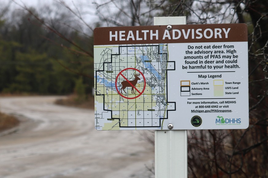 This photo provided by the National Wildlife Federation shows a sign warning hunters not to eat deer because of high amounts of toxic chemicals in their meat, in Oscoda, Mich., March 26, 2021. Wildlif ...