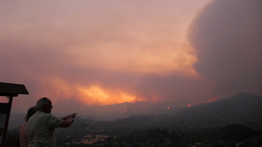epa09321434 People of a village look toward the fire in the Larnaca mountain region, Cyprus, 03 July 2021. The European Commission has mobilized the rescEU system, which tackles natural disasters, to  ...