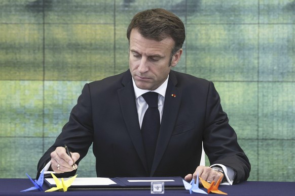 France&#039;s President Emmanuel Macron signs a book during his visit at Hiroshima Peace Memorial Museum in Peace Memorial Park as part of the G7 Hiroshima Summit in Hiroshima, western Japan, Friday,  ...