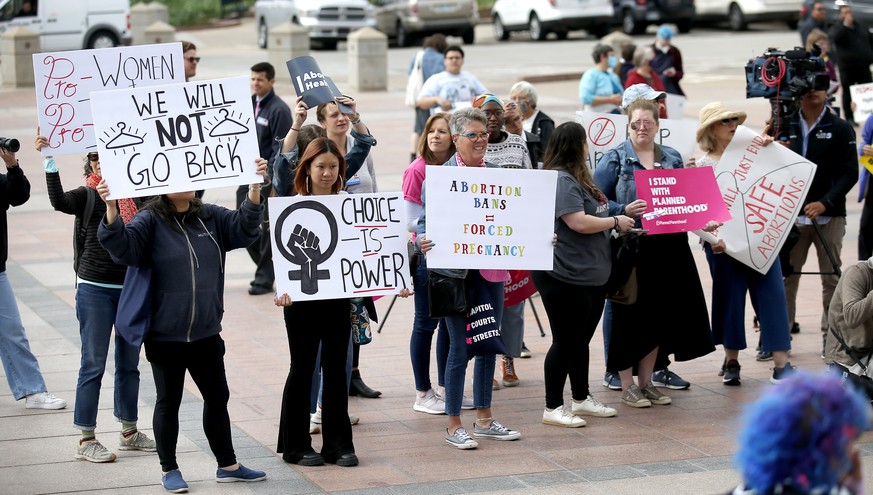 People hold signs during the Bans Off Oklahoma Rally on the steps on Oklahoma state Capitol in Oklahoma City, Tuesday, April, 5, 2022. (Sarah Phipps/The Oklahoman via AP)