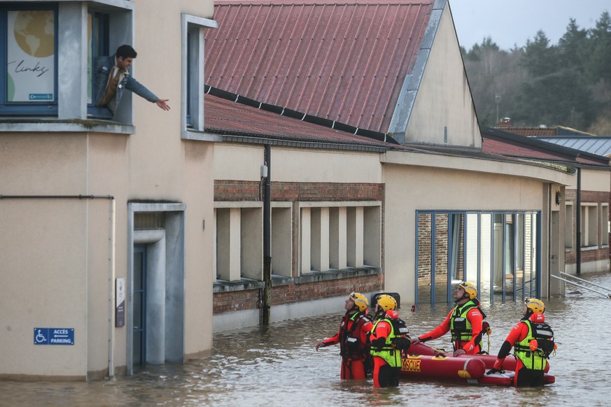 Les services d'urgence évacuent un habitant d'une rue inondée alors que la rivière Aa déborde à Arques, en France.