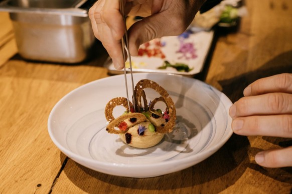 MARSEILLE, FRANCE - JULY 5: Chef Alexandre Mazzia prepares herbaceous chickpea pomade, peas, and smoked fish milk which will be served to athletes during the Olympic Games in his restaurant AM par Ale ...