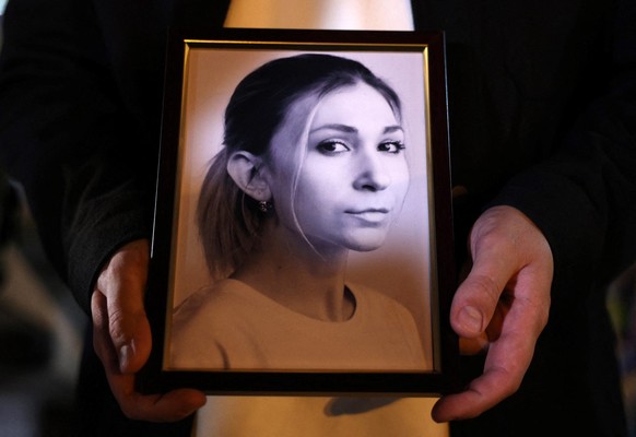 Un collègue de la journaliste ukrainienne Viktoria Rochchtchyna tient une photographie d’elle lors d’une cérémonie en sa mémoire, organisée devant un mémorial de fortune dédié aux soldats ukrainiens t ...