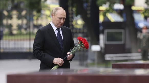 Le président russe Vladimir Poutine dépose des fleurs sur les plaques commémoratives de Hero Cities lors d&#039;une cérémonie de dépôt de gerbes sur la tombe du soldat inconnu à Moscou, en Russie, le  ...