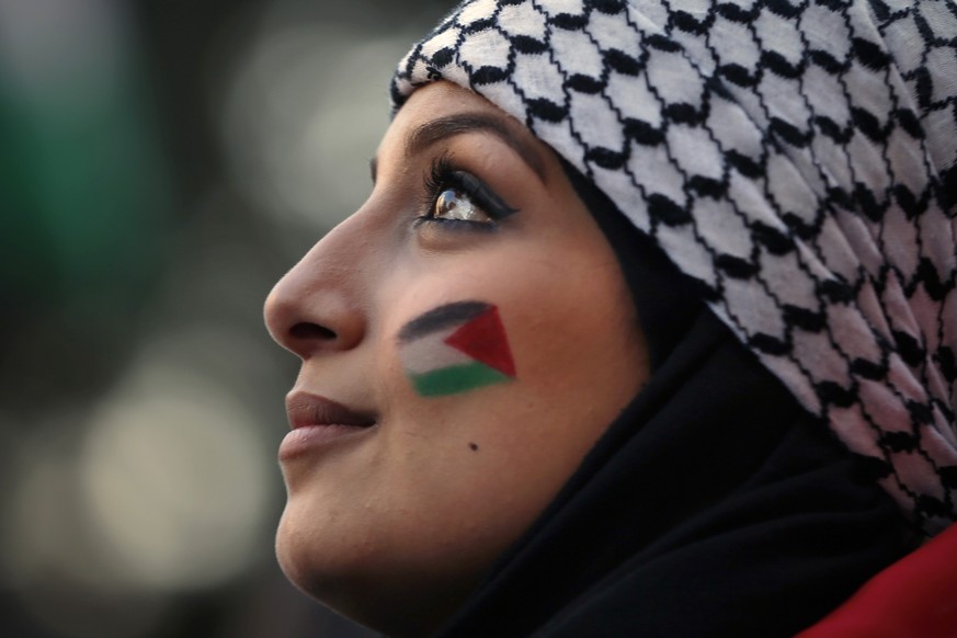 A Palestinian living in Lebanon painted Palestinian flags on her face during a march in support of Palestinians, in Beirut, Lebanon, Tuesday, May 18, 2021. (AP Photo/Bilal Hussein)