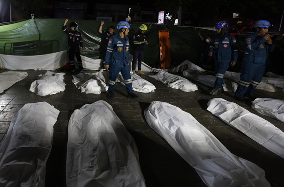 epa13107701 Rescue workers recover the bodies of fire victims outside the burned pub following a fire in Bangkok, Thailand, 13 July 2026. At least 27 people were killed after a fire engulfed the pub,  ...