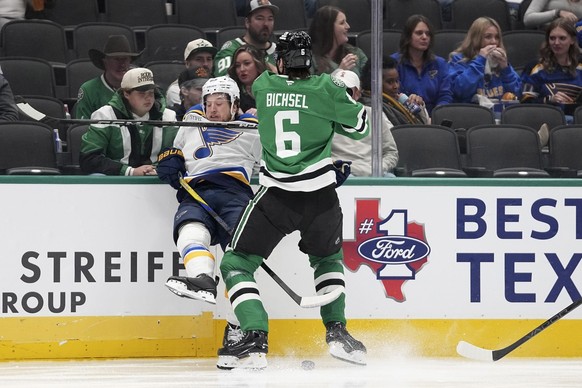 Dallas Stars defenseman Lian Bichsel (6) slams St. Louis Blues left wing Jake Neighbours, left, up against the boards in the second period of an NHL hockey game in Dallas, Saturday, Dec. 14, 2024. (AP ...