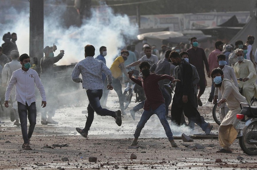 epa09132858 Supporters of Islamic political party Tehreek-e-Labbaik Pakistan (TLP), throw stones at the police during a protest to demand the release of their leader Saad Hussain Rizvi, in Lahore, Pak ...