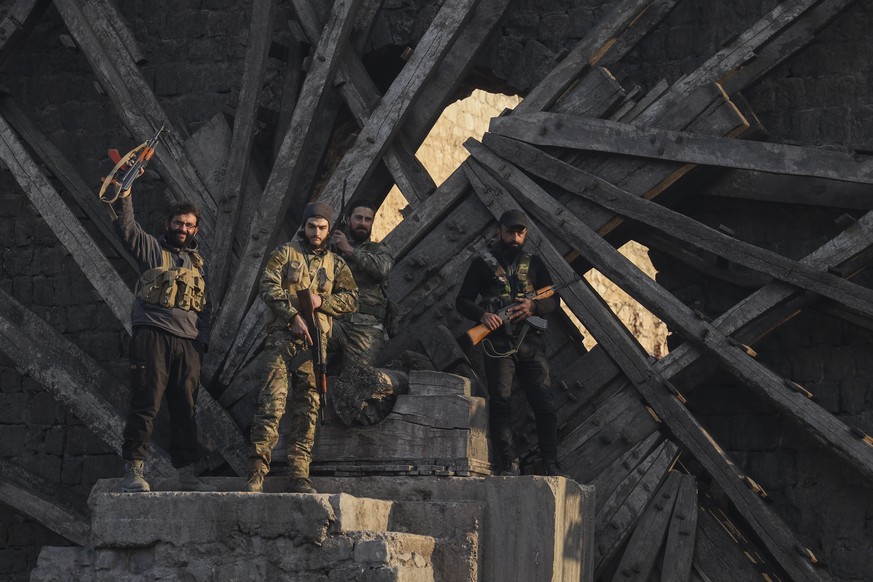 Insurgent fighters celebrate in the aftermath of the opposition&#039;s takeover of the city in downtown Hama, Syria, Friday, Dec. 6, 2024. (AP Photo/Omar Albam)