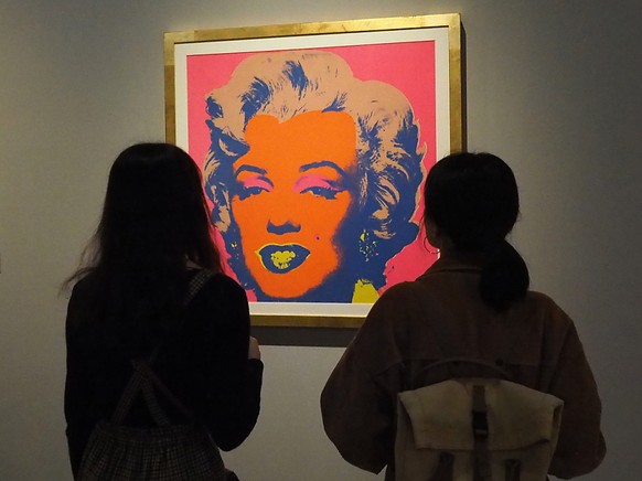 Des visiteurs, ici habillés, devant une œuvre d'Andy Warhol. 