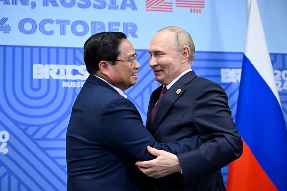 epa11681495 Russian President Vladimir Putin (R) greets Vietnamese Prime Minister Pham Minh Chinh during their bilateral meeting on the sidelines of the BRICS summit in Kazan, Russia, 24 October 2024. ...
