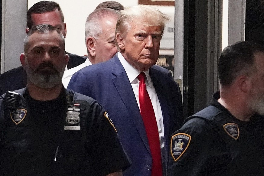 FILE - Former President Donald Trump is escorted to a courtroom, April 4, 2023, in New York. Trump?s bond has been set at $200,000 in the Georgia case accusing the former president of scheming to over ...