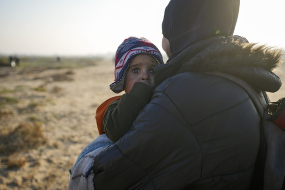 A Palestinian woman holds a baby as they return to their home in the northern Gaza Strip, following Israel&#039;s decision to allow thousands of them to go back for the first time since the early week ...