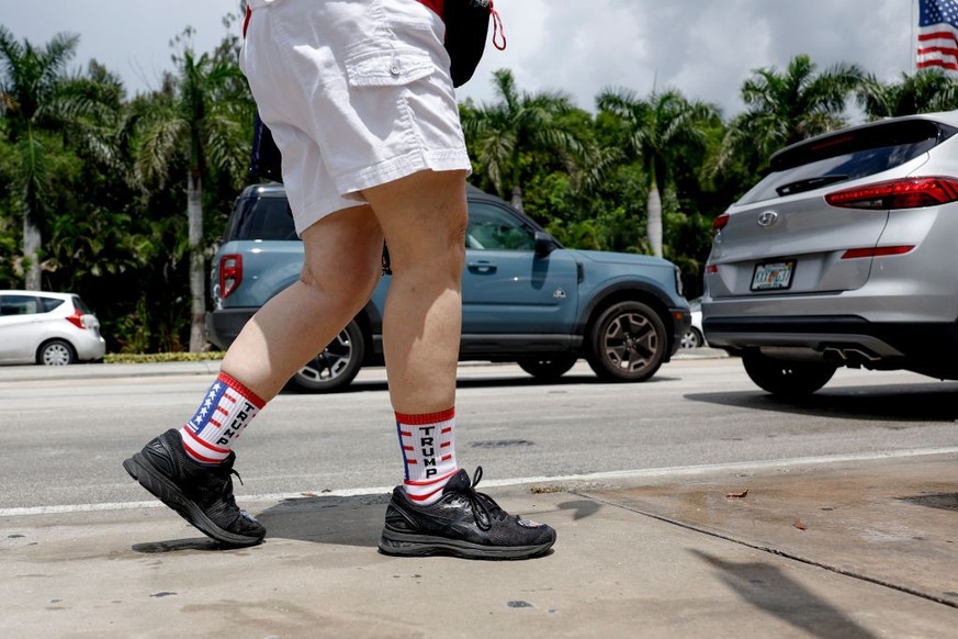 DORAL, FLORIDA - JUNE 12: A supporter of former U.S. President Donald Trump wears socks with Trump on them as they walk past the Trump National Doral resort and await his arrival on June 12, 2023 in D ...