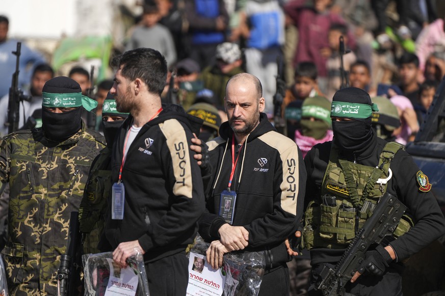 Hostages Iair Horn, 46, Israeli-Argentine, center, and Sagui Dekel Chen, 36, left, Israeli-American are escorted by Hamas and Islamic Jihad fighters before being handed over to the Red Cross in Khan Y ...