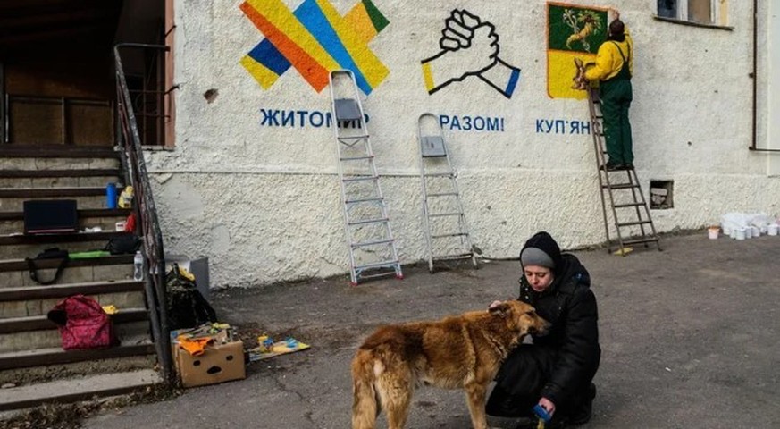 La vie revient lentement à Kupjansk: des artistes peignent la façade de l'hôtel de ville.