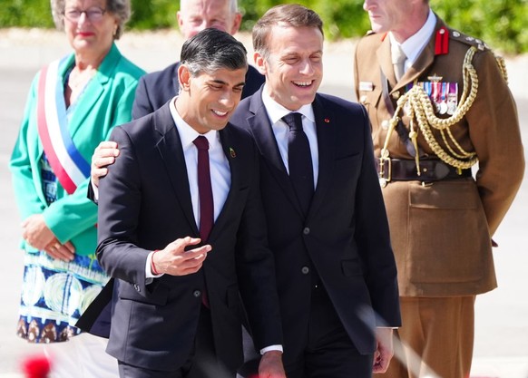 French President Emmanuel Macron with Prime Minister Rishi Sunak arrive for the UK national commemorative event for the 80th anniversary of D-Day, held at the British Normandy Memorial in Ver-sur-Mer, ...