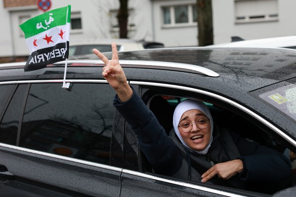 epa11764575 A supporter of the Syrian opposition residing in Germany celebrates the rebel take over of Damascus, in Berlin, Germany, 08 December 2024. Syrian rebels entered Damascus on 08 December 202 ...