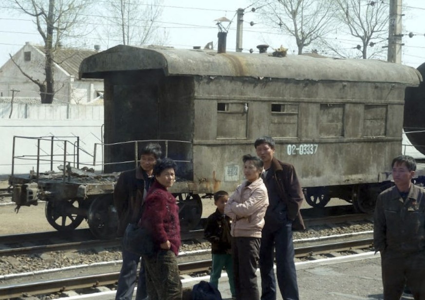 Des Nord-Coréens attendent sur le quai d’une gare ferroviaire de la province du Pyongan du Nord, sur la ligne principale reliant la capitale Pyongyang à la ville frontalière chinoise de Dandong, en av ...