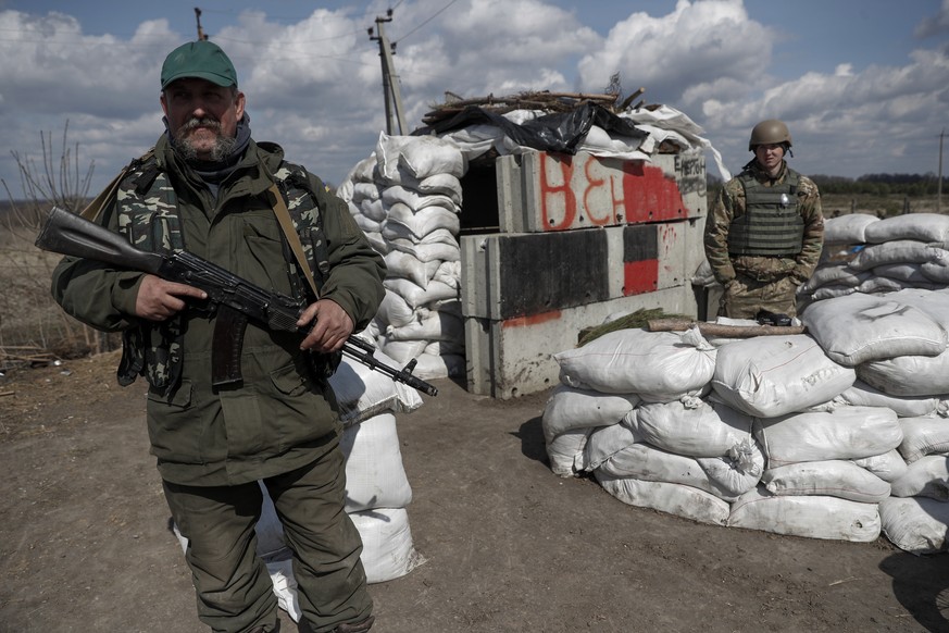 epa09873738 Ukrainian Territorial Defense Forces personnel stand guard at a checkpoint in the suburbs of Kharkiv, Ukraine, 06 April 2022. On 24 February, Russian troops entered Ukrainian territory to  ...