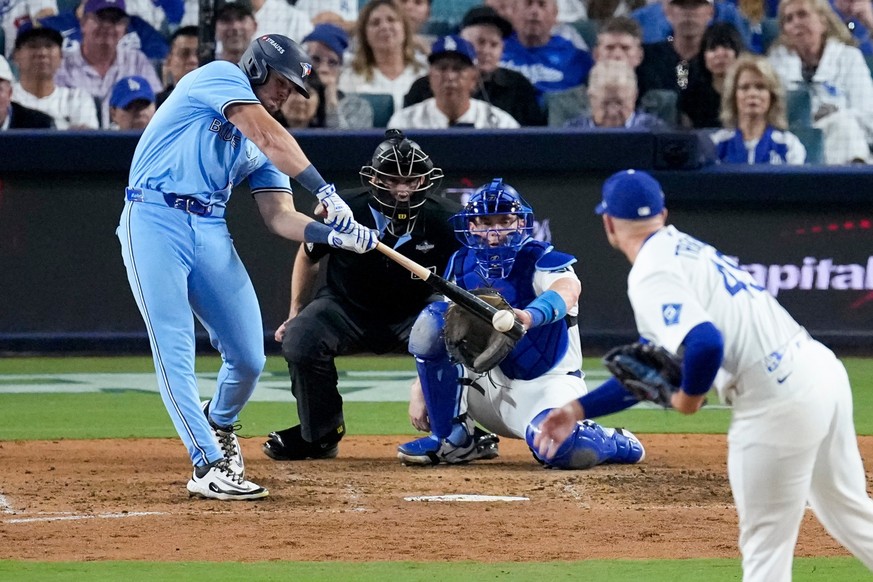 Toronto Blue Jays&#039; Addison Barger connects for an RBI single off Los Angeles Dodgers pitcher Blake Treinen, right, during the seventh inning in Game 4 of baseball&#039;s World Series, Tuesday, Oc ...