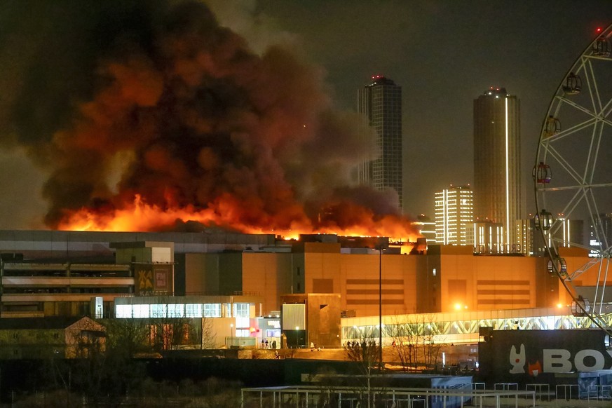 A massive blaze is seen over the Crocus City Hall on the western edge of Moscow, Russia, Friday, March 22, 2024. Several gunmen have burst into a big concert hall in Moscow and fired automatic weapons ...