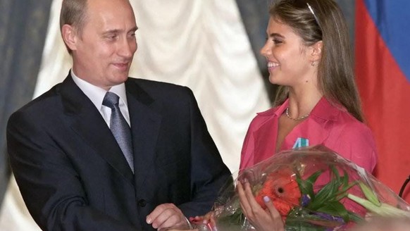Vladimir Poutine présentant des fleurs à la championne olympique Alina Kabaeva, après lui avoir décerné l'ordre de l'amitié le 8 juin 2001 en Russie.