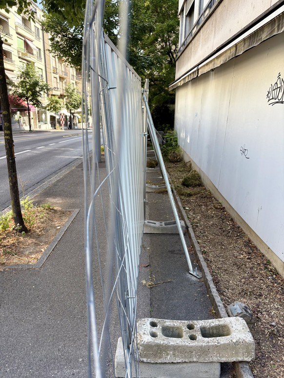 renforcement de la strucuture de palissade métallique sur le trottoir pour un chantier Implenia à Lausanne après intervention de la police et de la Ville