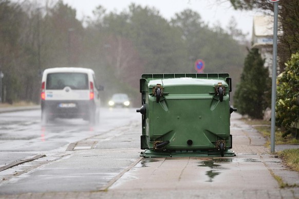 11.03.2021, Schleswig-Holstein, St. Peter-Ording: Eine umgekippte M�lltonne liegt bei Sturm auf einem Gehweg in St. Peter-Ording. Nach Angaben des Deutschen Wetterdienstes werden am Donnerstag an der  ...