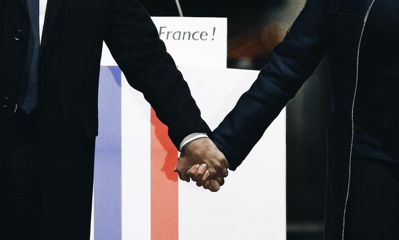 French President-elect Emmanuel Macron holds hands with his wife Brigitte during a victory celebration outside the Louvre museum in Paris, France, Sunday, May 7, 2017. Speaking to thousands of support ...