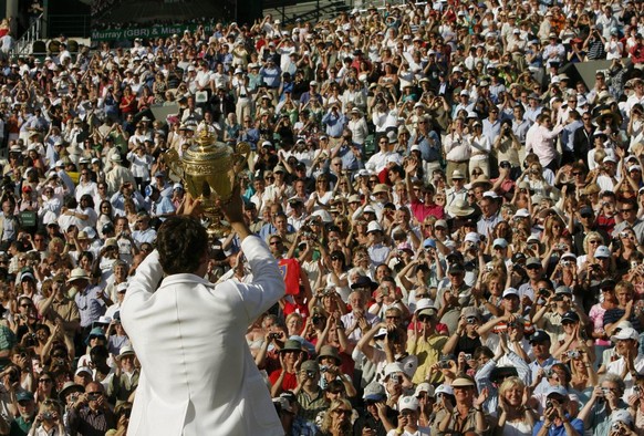 Switzerland&#039;s Roger Federer holds up the trophy to show the crowd, after defeating Rafael Nadal to win his fifth consecutive Men&#039;s Singles Championship on the Centre Court at Wimbledon, Sund ...