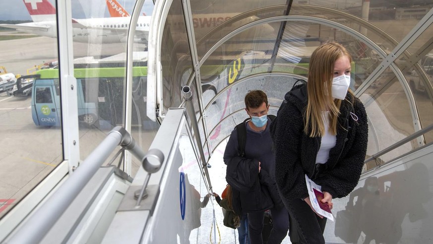Passengers wearing a face masks to protect against the spread of coronavirus COVID-19 boarding to aircraft of the Swiss International Air Lines prior to departure to London during the resumption parti ...