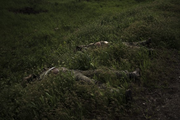The bodies of two dead Russian soldiers lay on the side of the road in the village of Vilkhivka, recently retaken by Ukrainian forces near Kharkiv, Ukraine, Monday, May 9, 2022. (AP Photo/Felipe Dana)
