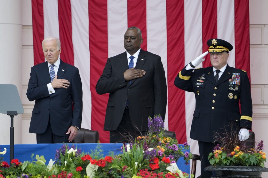 President Joe Biden stands with Defense Secretary Lloyd Austin and Chairman of the Joint Chiefs of Staff Gen. Mark Milley during the playing of &quot;Taps,&quot; at the Memorial Amphitheater of Arling ...