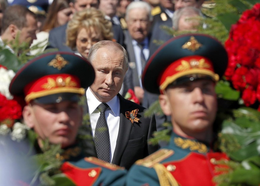 epa06721421 Russian President Valdimir Putin (C) attends a wreath laying ceremony at the Tomb of The Unknown Soldier after Victory Day parade in Moscow,Russia, 09 May 2018. Russia marks the 73rd anniv ...