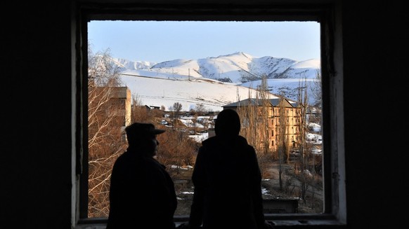 Lyubov Tyasova, the 50-year-old tour guide, and her son Vadim, 13, stand inside an abandoned Soviet-era building in the small town of Orlovka, some 90 kms from Bishkek, on March 11, 2025. Like million ...
