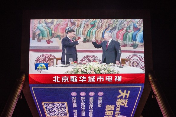 epa10536640 A screen shows Chinese President Xi Jinping raising a glass with Russian President Vladimir Putin during their meeting in Moscow the previous day, in Beijing, China, 22 March 2023. The Chi ...